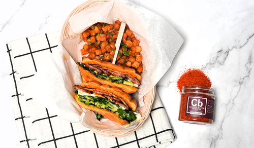Bacon Breakfast Sandwich with homestyle potatoes next to a jar of Spiceology Candied Bacon Sriracha sesoning